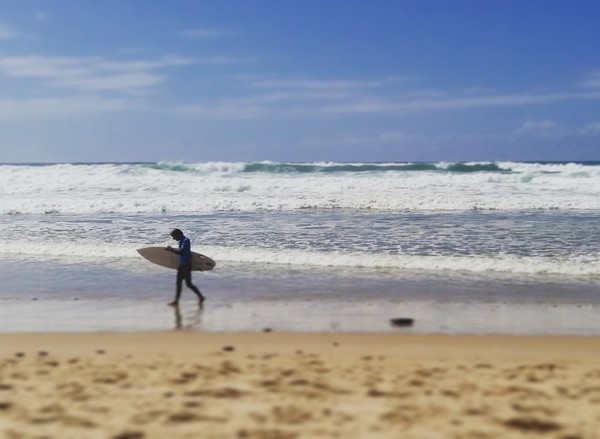 Surfeur sur la plage de Lacanau face aux vagues de l'océan Atlantique