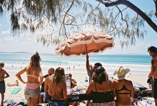 Famille et amis à la plage sous un parasol, protégés de la canicule